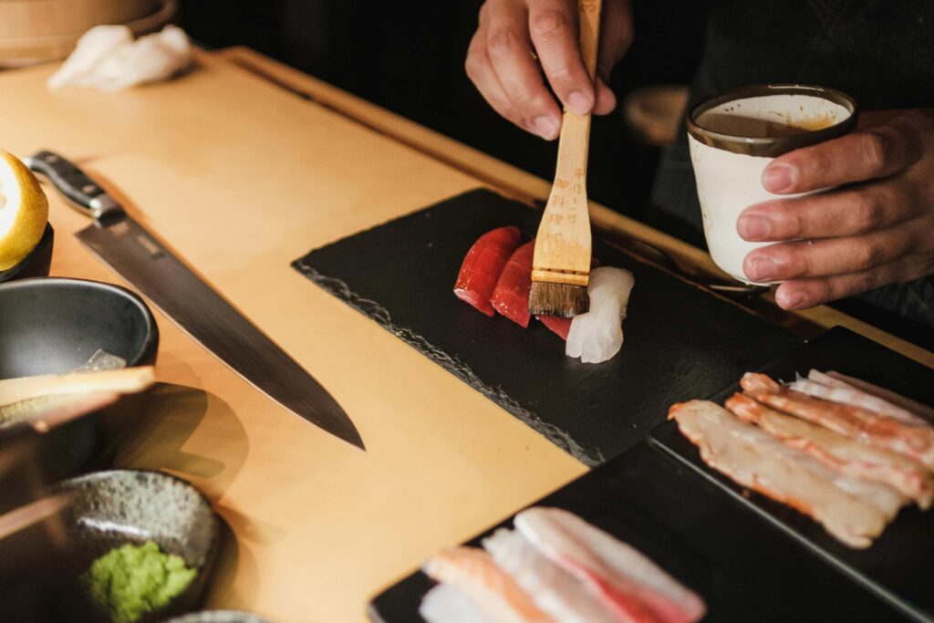 A sushi chef preparing sushi, showcasing the level of detail they put into preparing the sushi.