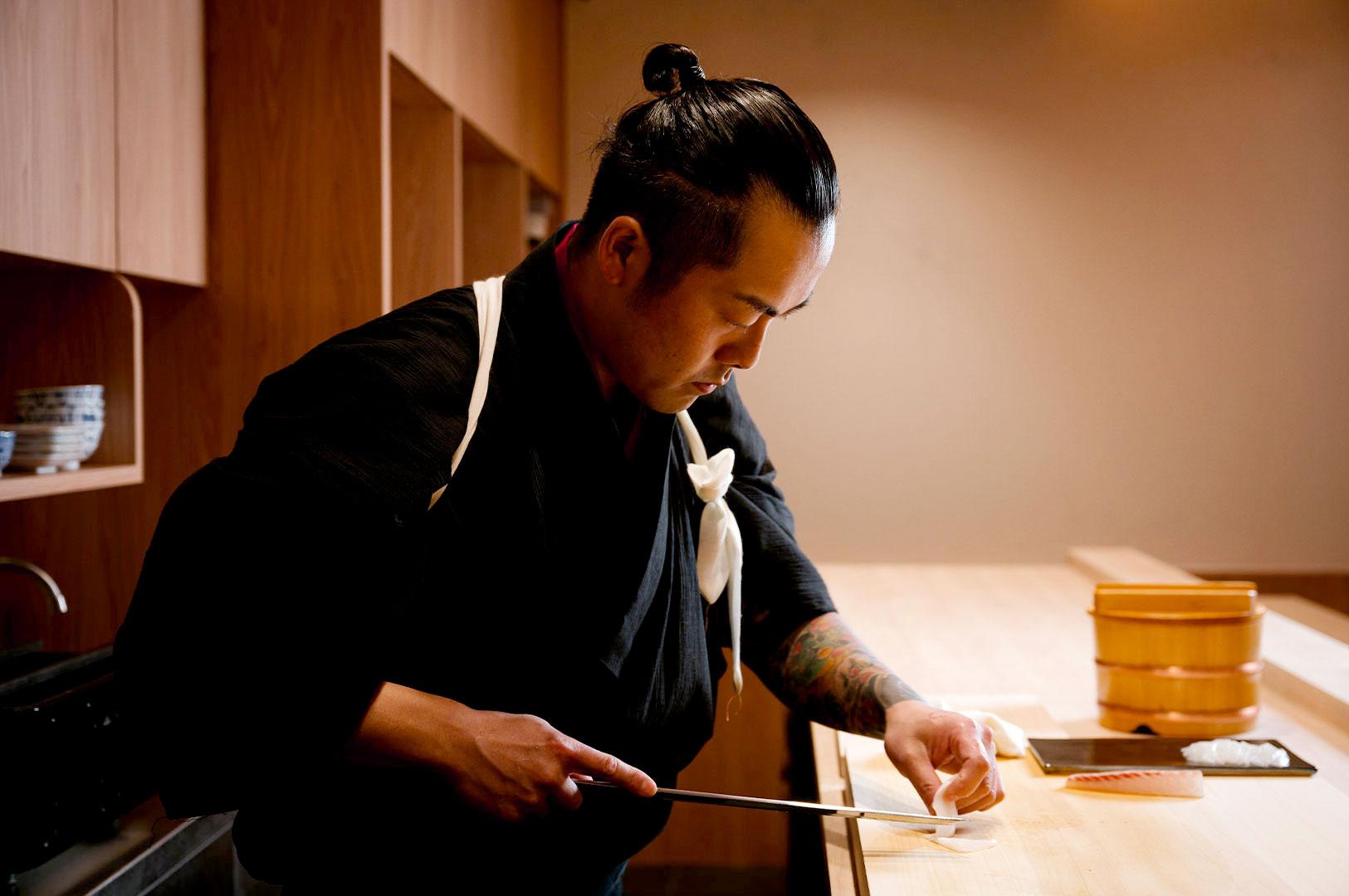 Sushi chef preparing fresh nigiri at affordable omakase restaurant Singapore