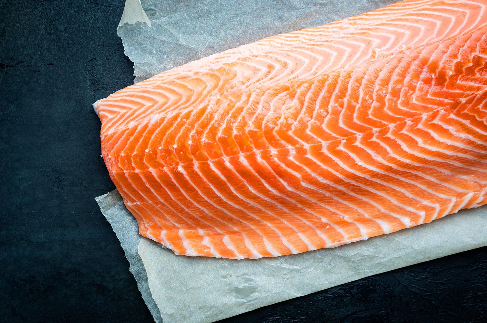 Raw salmon fillet close-up showing marbling and texture