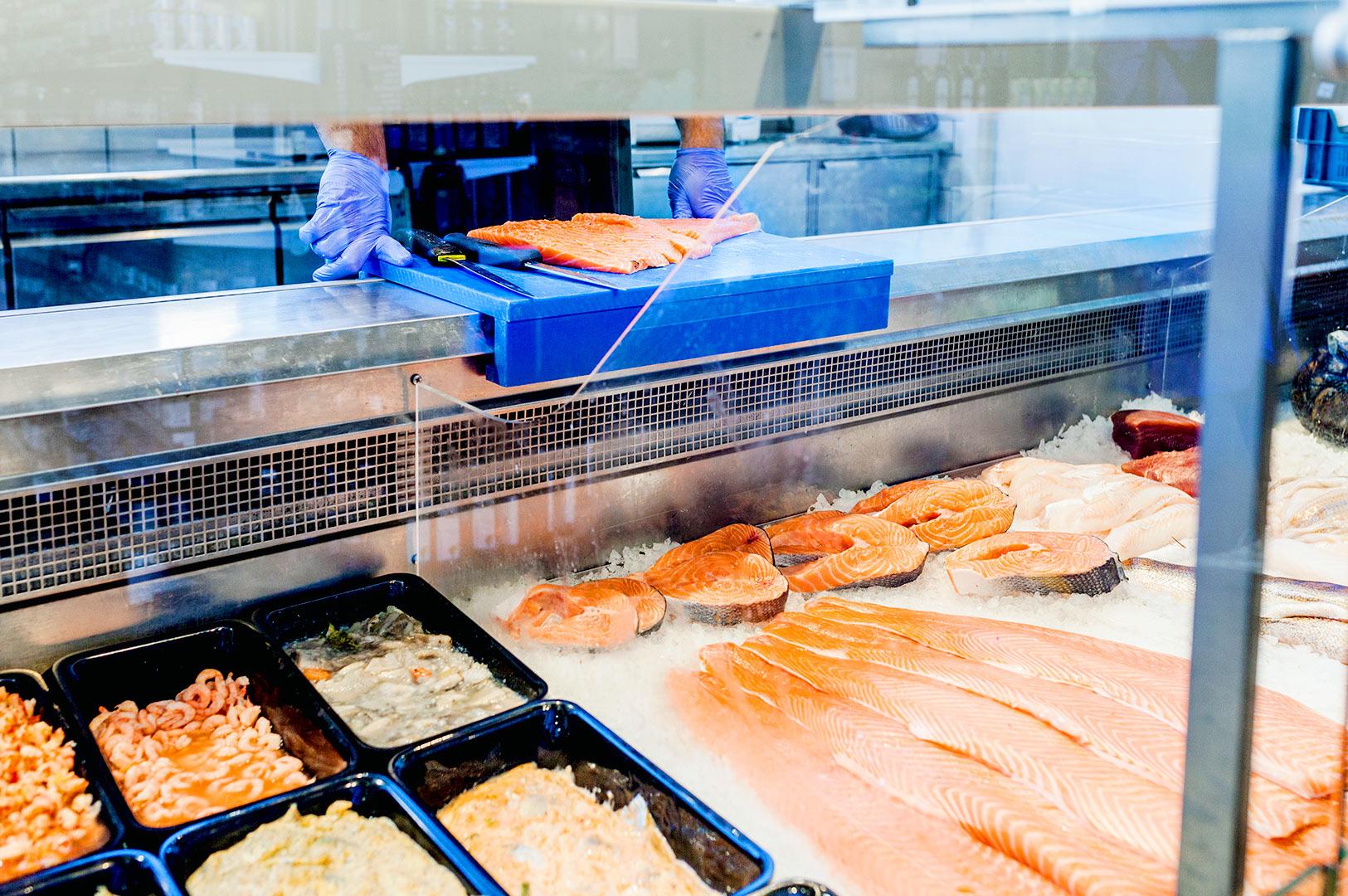 Salmon fillets displayed on ice at a seafood counter