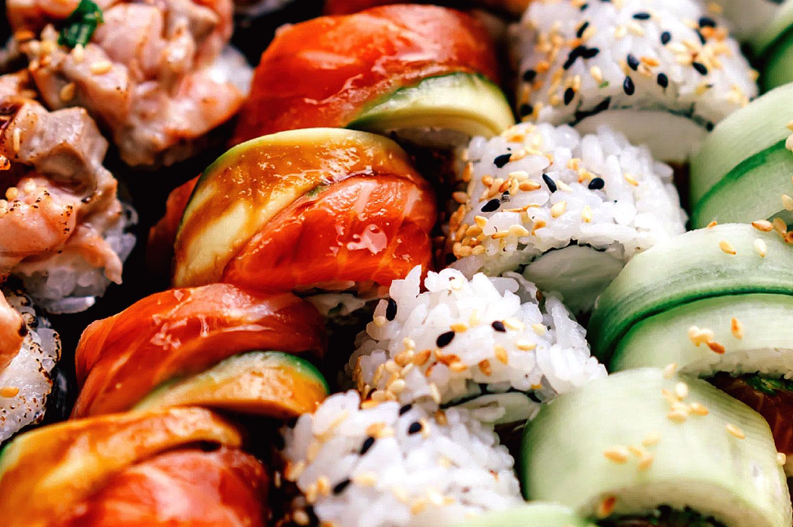 Assorted sushi platter close-up with salmon, avocado, and maki rolls