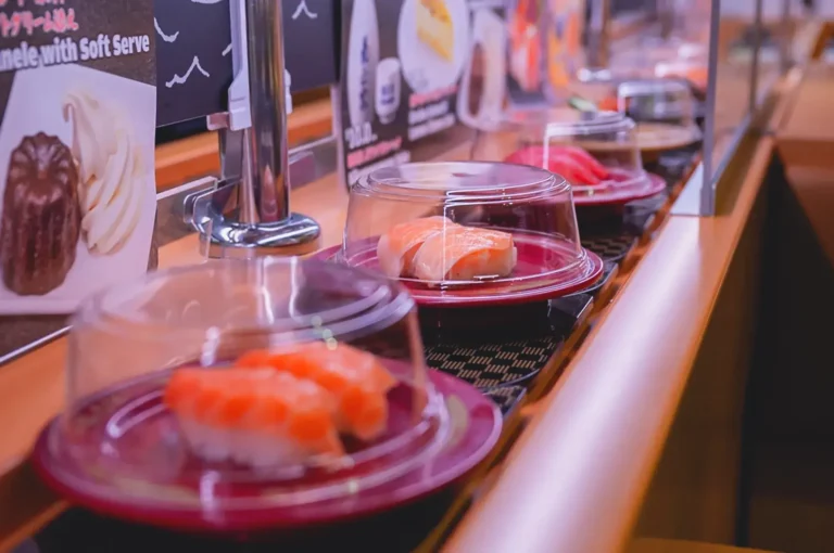 Affordable sushi at Sushiro Singapore with salmon and tuna plates moving along a conveyor belt in a casual dining setting