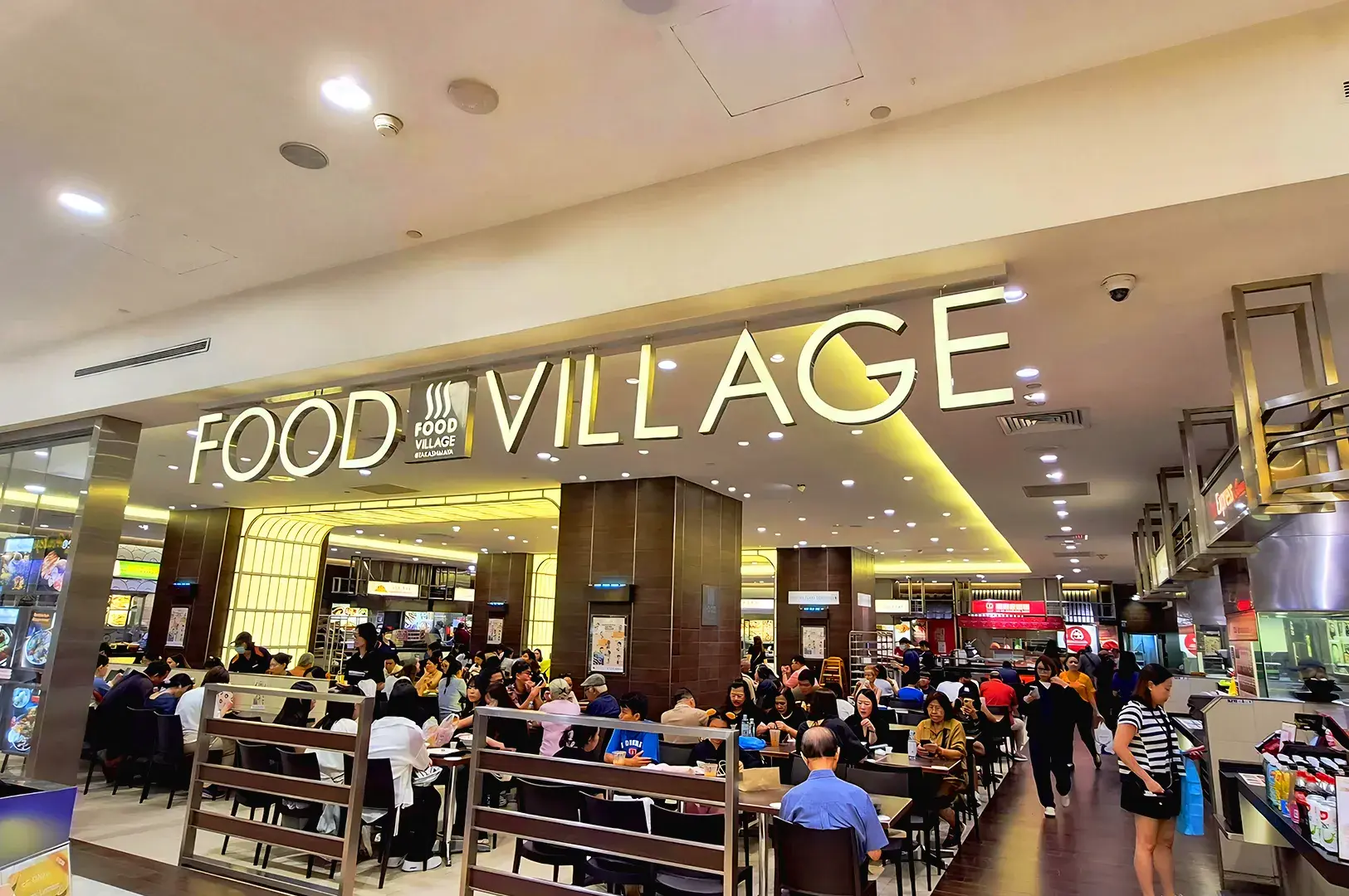 Food Village at Takashimaya Singapore crowded with diners enjoying Japanese food and Asian cuisine in a modern food hall setting along Orchard Road