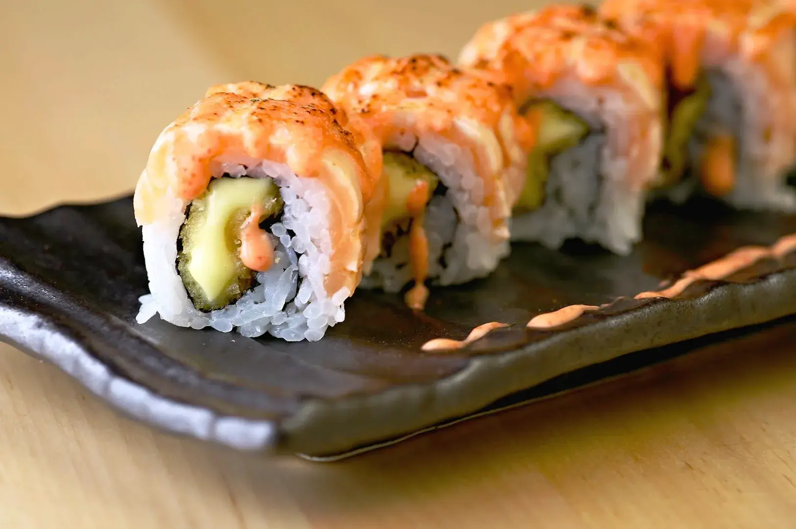 Aburi sushi roll with flame-seared salmon and creamy sauce, representing modern fusion sushi and Japanese food adaptation in Singapore