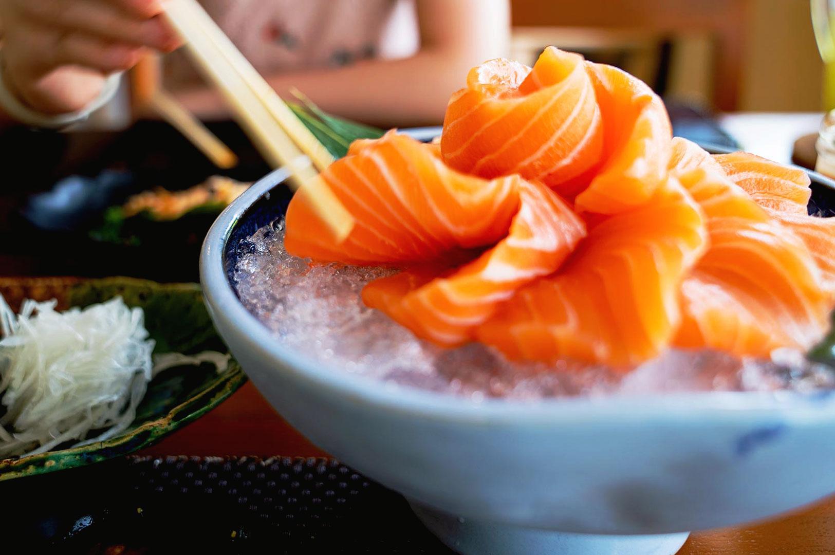 Fresh salmon sashimi platter served on ice at Japanese restaurant in Singapore with chopsticks and authentic sashimi presentation