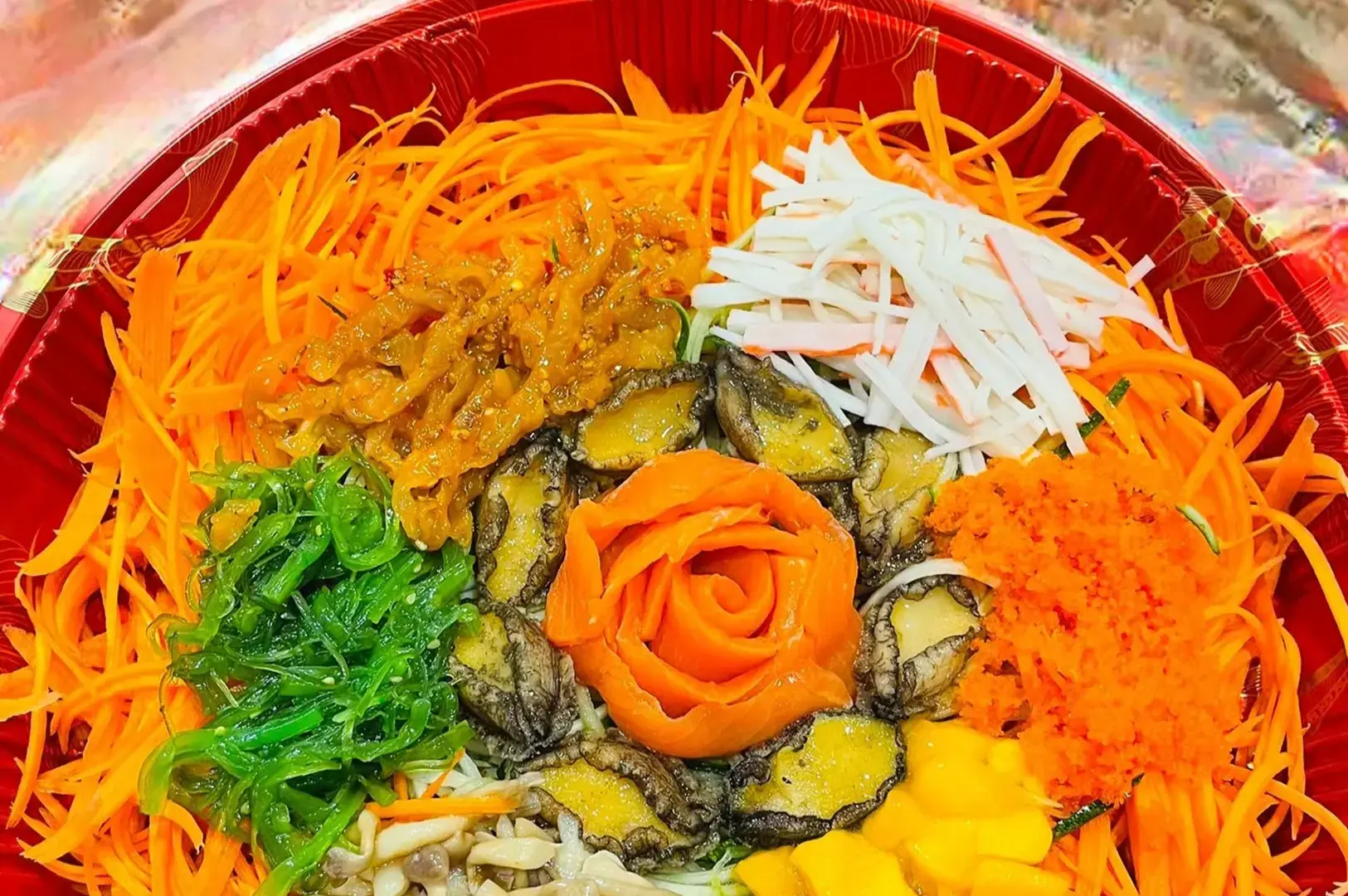 A colorful sushi bowl with shredded vegetables, mushrooms, and a carrot rose.