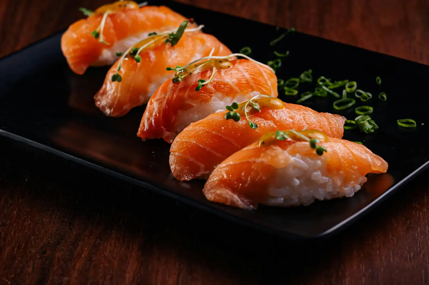 Salmon nigiri on black plate