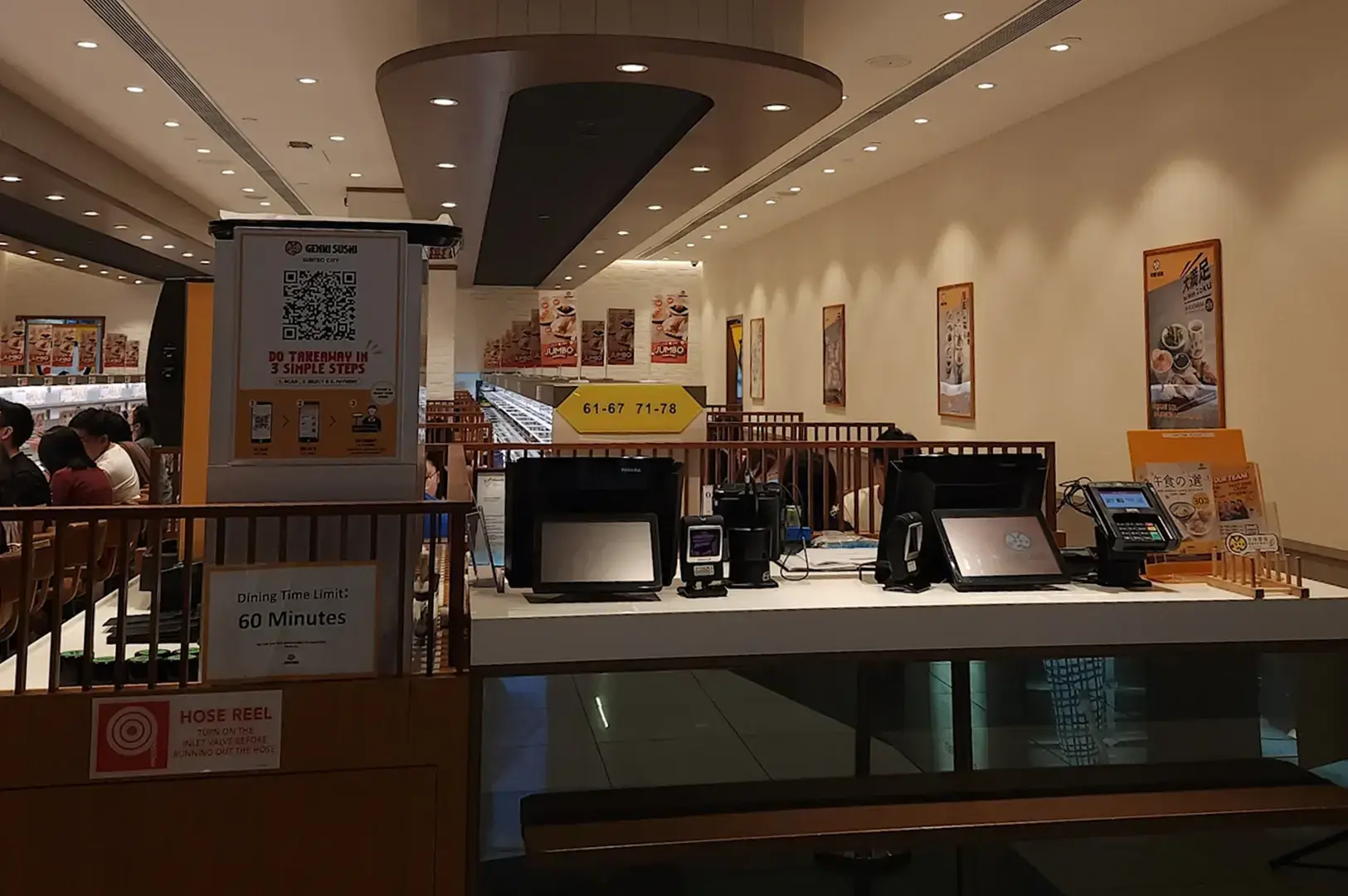 Genki Sushi counter with ordering kiosks and menu displays