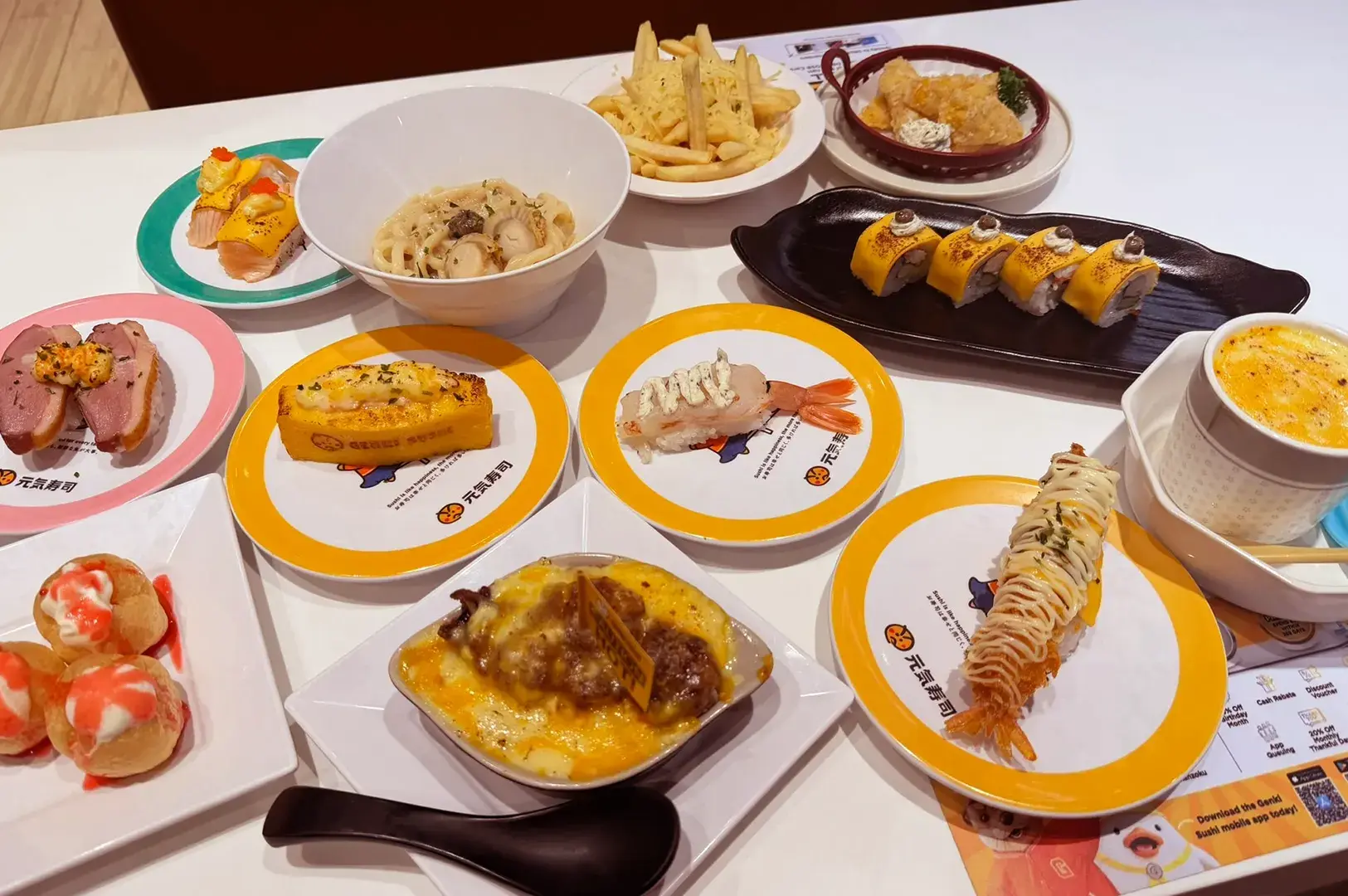 Multiple conveyor belt sushi plates with various dishes on white table